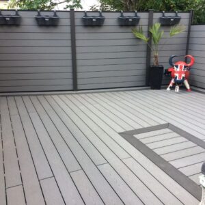 product image of hyperion explorer stone grey composite decking installed outside with fencing